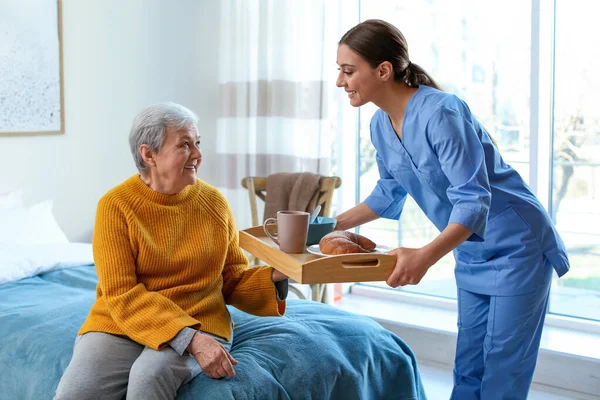 Cuidador Que Serve Jantar Para Mulher Idosa Hospício Geriátrico — Fotografia de Stock