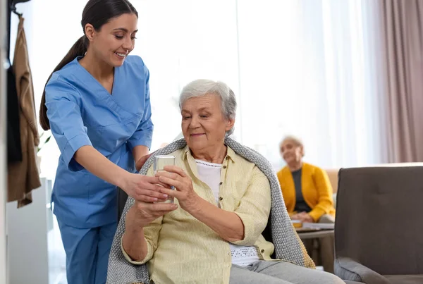 Zorgverlener Geeft Water Aan Oudere Vrouw Geriatrisch Hospice — Stockfoto