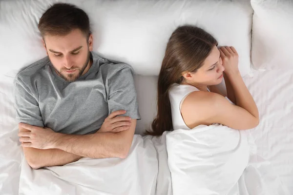 不安的年轻女子接近熟睡的丈夫躺在床上 尽收眼底 关系问题 — 图库照片