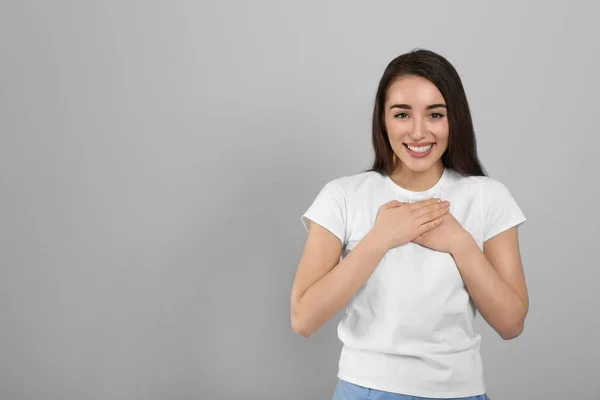 Hermosa Mujer Agradecida Con Las Manos Pecho Sobre Fondo Gris — Foto de Stock