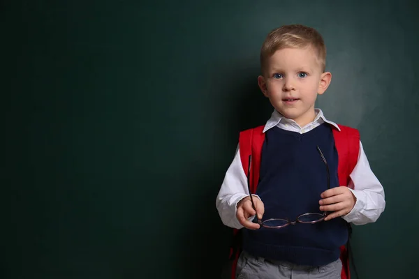 Cute little child near chalkboard, space for text. First time at school