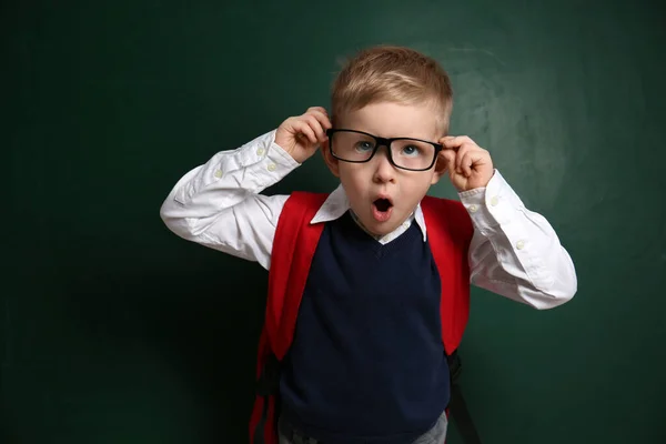 黒板の近くに眼鏡をかけた面白い小さな子供 学校で初めて — ストック写真