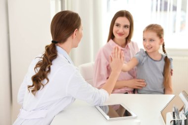 Anne ve kızı çocuk doktoru ziyaret etti. Doktor hastanede hasta ile çalışma