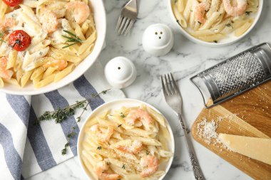 Beyaz mermer masada servis edilen karidesli lezzetli makarna.