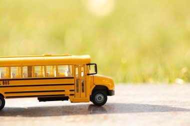 Güneşli bir günde dışarıda sarı oyuncak okul otobüsü. Öğrenci taşımacılığı
