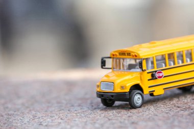 Açık hava yolundaki sarı oyuncak okul otobüsü. Öğrenci taşımacılığı