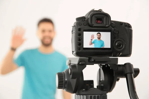 Jovem Blogueiro Filmando Vídeo Com Câmera Contra Fundo Branco Foco — Fotografia de Stock