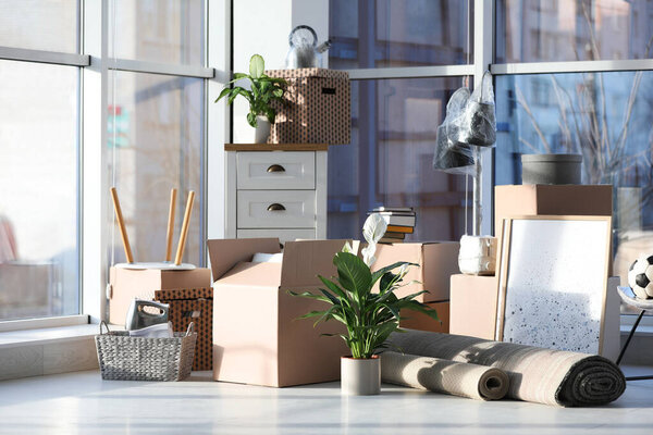 Картонные коробки и домашние вещи в гостиной. День переезда
