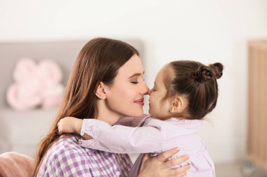 Young mother with little daughter at home