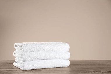 Ahşap masada temiz banyo havluları yığını. Metin için boşluk