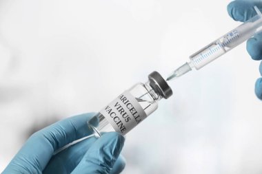 Şırıngayı suçiçeği aşısıyla dolduran doktor, yakın plan. Varicella virüs önleme
