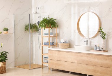 Stylish bathroom interior with countertop, shower stall and houseplants. Design idea