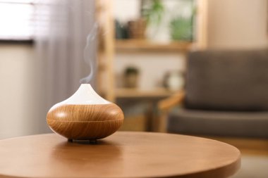 Aroma yağı yayıcı evdeki ahşap masada, yazı için yer var. Oda spreyi
