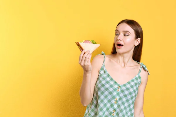 Jovem Mulher Comendo Sanduíche Saboroso Fundo Amarelo Espaço Para Texto — Fotografia de Stock