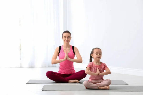 小女儿在家里练瑜伽的年轻妈妈 — 图库照片