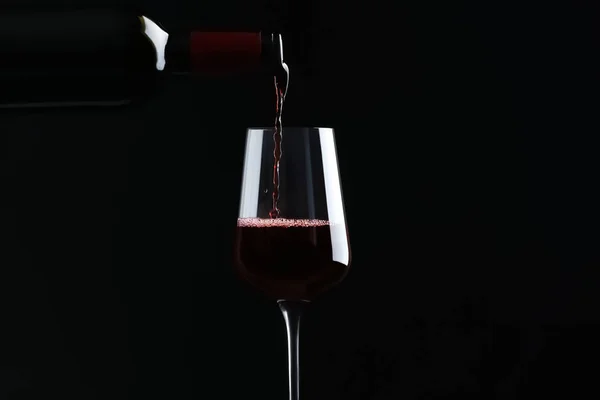 Verser Vin Rouge Bouteille Dans Verre Sur Fond Noir — Photo