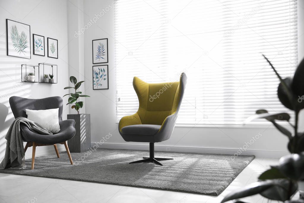 Comfortable armchairs near window in light room