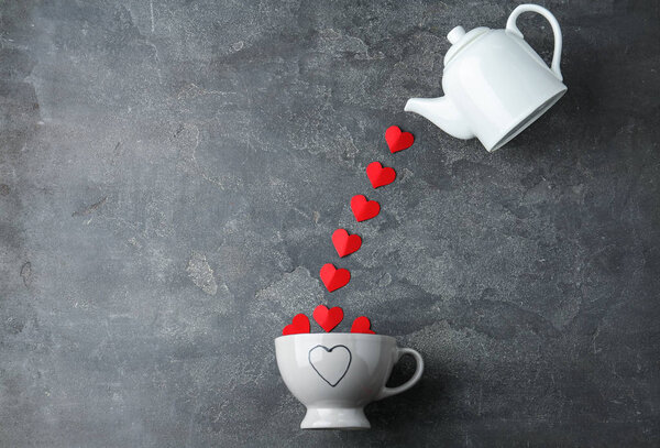 Плоская композиция с чайником, чашкой и красной бумагой сердца на сером фоне
