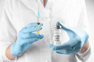 Doktor suçiçeği aşısı ve şırınga tutuyor, yakın plan. Varicella virüs önleme