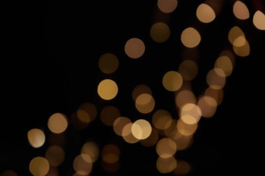 Siyah arkaplandaki güzel ışıkların bulanık görüntüsü. Bokeh etkisi