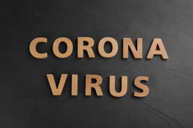 Sözcükler CORONA VIRUS siyah masa üzerinde ahşap harflerden yapılmış, üst görünüm