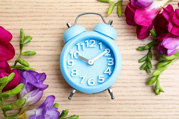 Reloj Despertador Azul Claro Flores Primavera Mesa Madera Puesta Plana — Foto de Stock