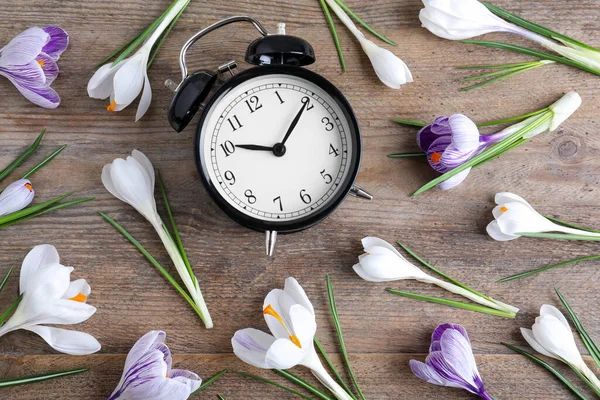 Fekete Ébresztőóra Tavaszi Virágok Asztalon Lapos Fektetés Időváltozás — Stock Fotó
