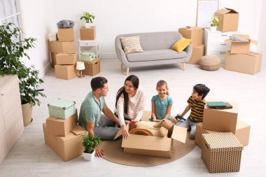 Mutlu aile yeni evlerinde kutuları boşaltıyor.