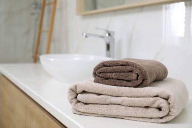 Banyo tezgahında bir yığın temiz havlu var. Metin için boşluk