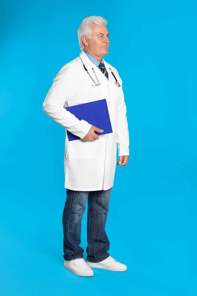 Açık Mavi Arka Planda Panosu Olan Kıdemli Doktor — Stok fotoğraf