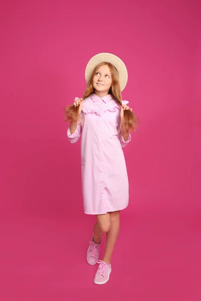 フル長さポートレートの十代の女の子の帽子でピンクの背景 — ストック写真