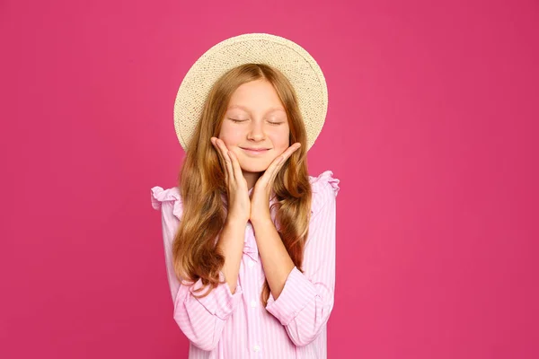 ポートレートの十代の女の子の帽子でピンクの背景 — ストック写真