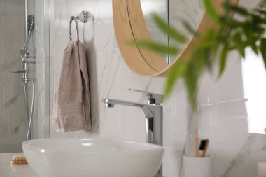 Banyo içinde ayna, tezgah ve duvarda yumuşak havlu var.