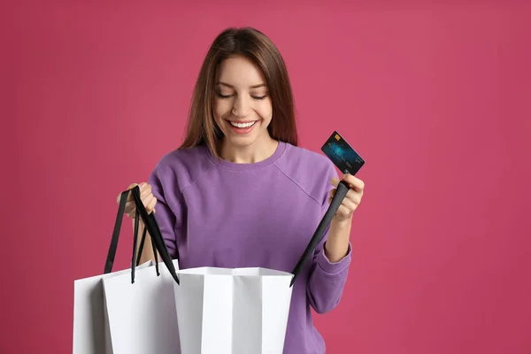 Glückliche Junge Frau Mit Kreditkarte Und Einkaufstaschen Auf Rosa Hintergrund — Stockfoto