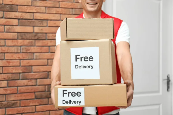 Courier Segurando Parcelas Com Adesivos Entrega Gratuita Dentro Casa Close — Fotografia de Stock