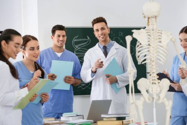 Tıp öğrencileri sınıfta insan iskeleti anatomisi okuyor.