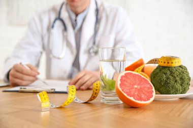 Sağlıklı ürünler, mezura ve arka planda bulanık beslenme uzmanı