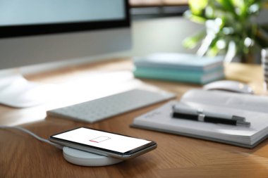 Modern işyeri ve akıllı telefon kablosuz ped ile şarj ediliyor