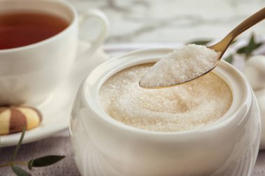 Kaşık ve granüllü şeker masada, yakın plan.