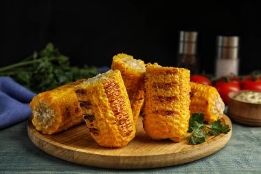 Lezzetli ızgara mısır koçanları mavi ahşap masada.