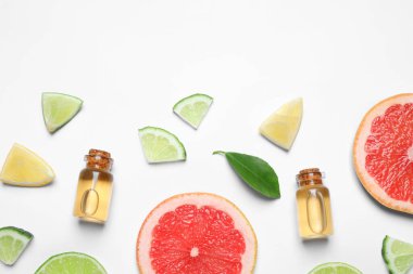 Flat lay composition with bottles of citrus essential oil on white background