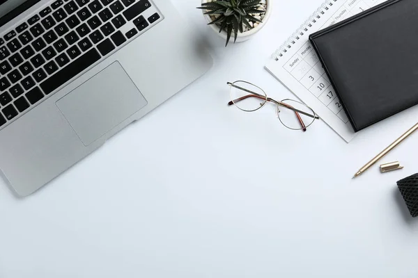 白色背景的笔记本电脑 眼镜和文具的组合 顶部视图 — 图库照片