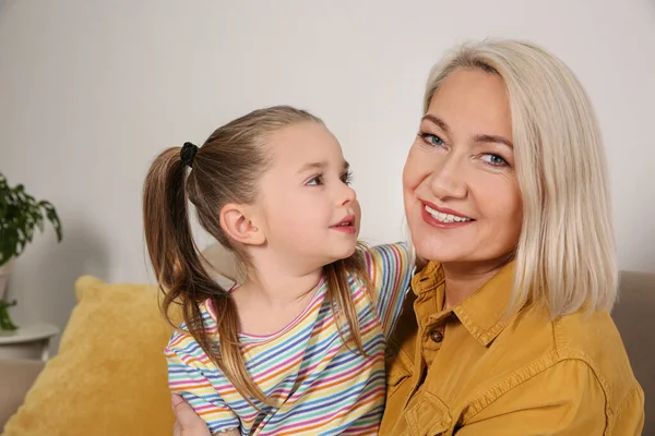 Yetişkin bir kadın ve küçük torunu evde.