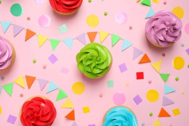 Açık pembe arka planda renkli doğum günü kekleri, düz uzanma