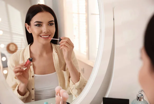 Vacker Ung Kvinna Tillämpa Makeup Nära Spegeln Inomhus — Stockfoto