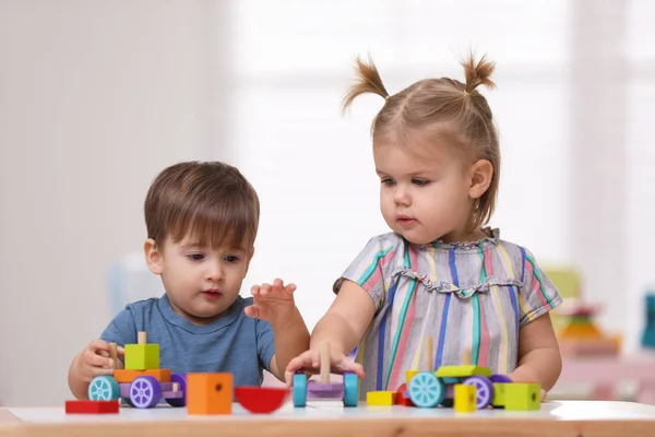 Schattige Kleine Kinderen Die Met Speelgoed Aan Tafel Spelen — Stockfoto