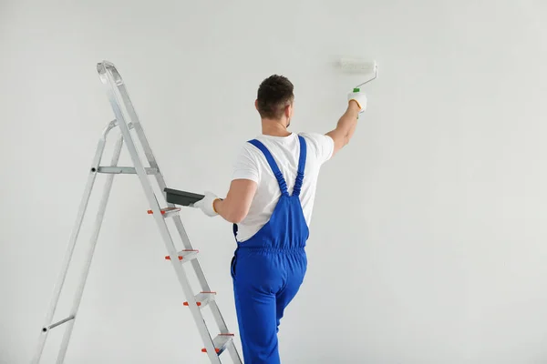 Mann Bemalt Wand Mit Weißem Farbstoff Drinnen Rückseite — Stockfoto