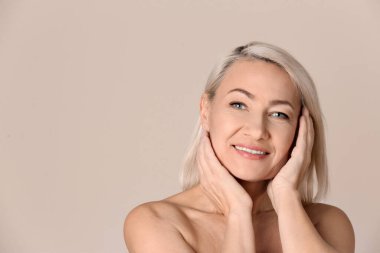 Bej arka planda güzel olgun bir kadının portresi. Metin için boşluk