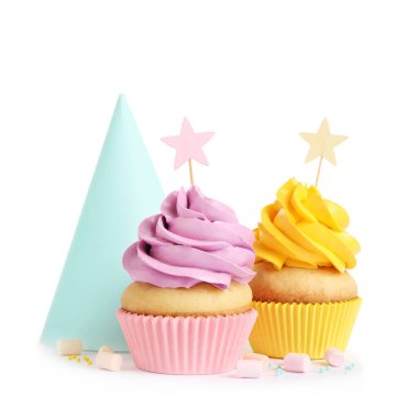 Lezzetli doğum günü kekleri ve beyaz arka planda parti şapkası.