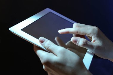 Koyu arkaplanda tablet kullanan kadın, kapat
